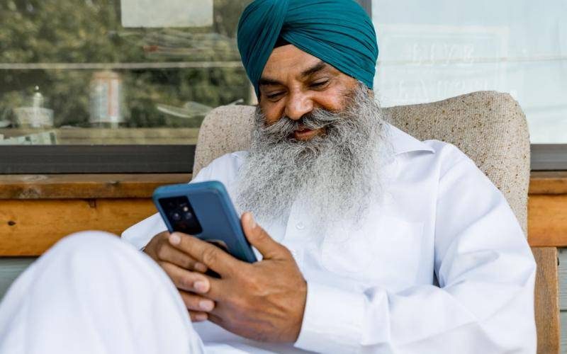 Smiling man reading a text message on his phone
