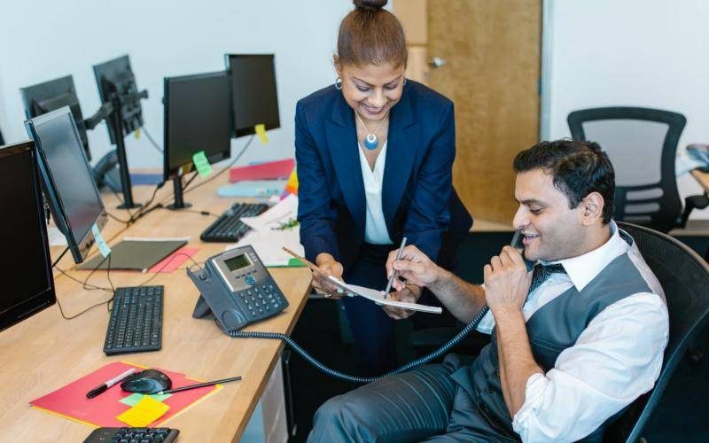Support team member on a call while a colleague shares notes
