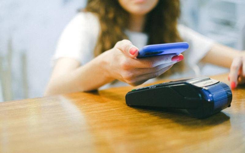 Customer paying with a smartphone at a card machine